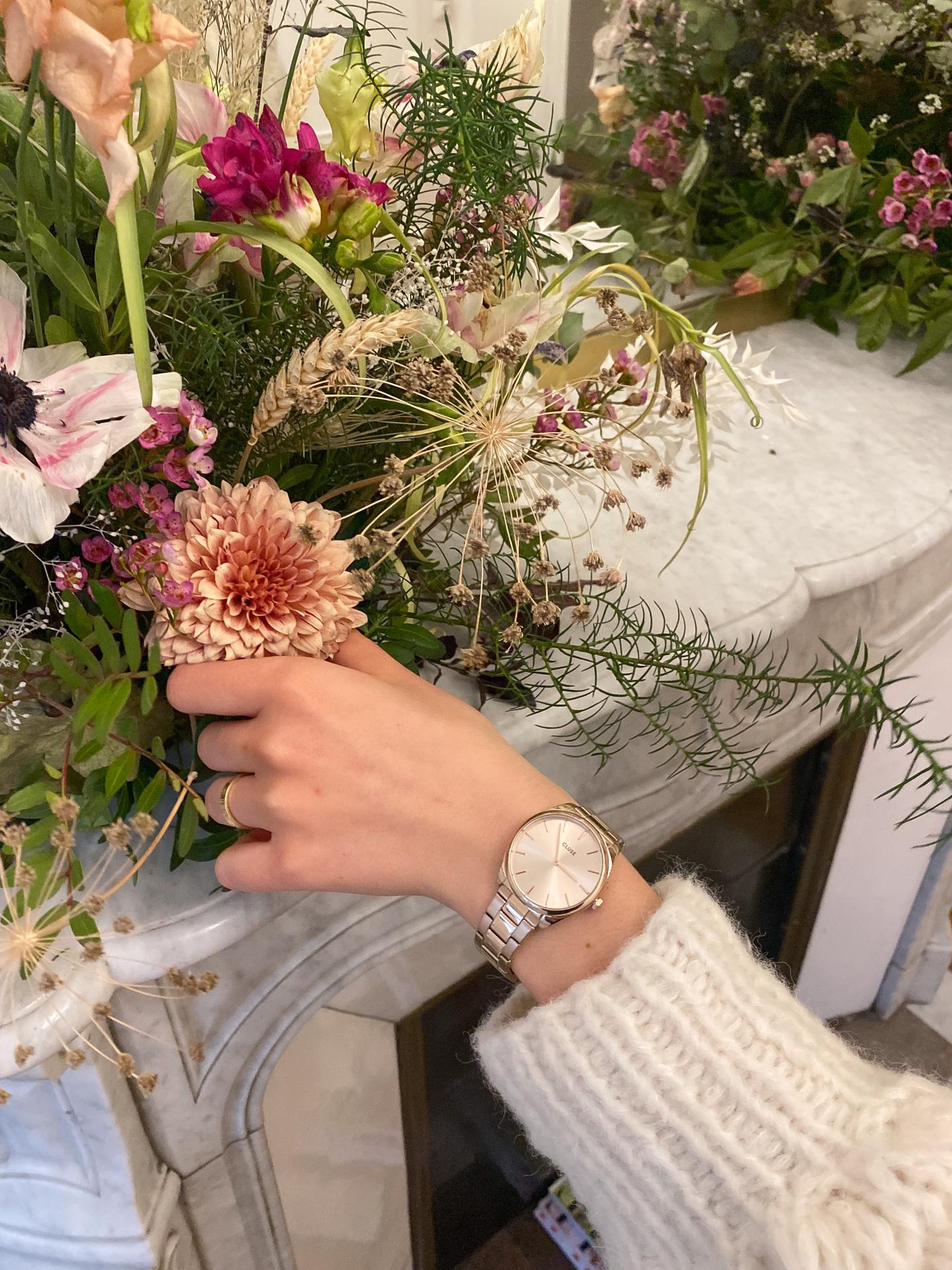 Main avec une montre au poignet tenant une fleur