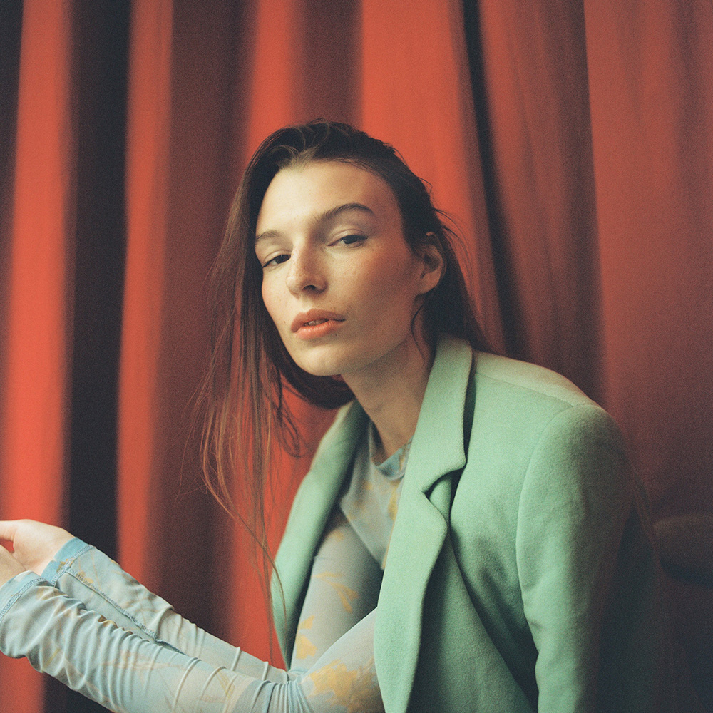 girl sitted wearing green looking at the camera